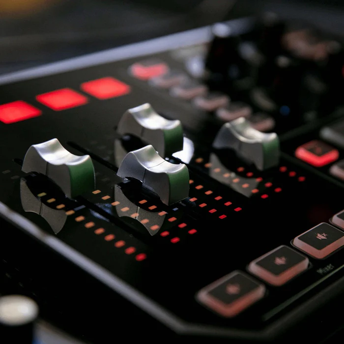 Close-up of GoXLR motorized faders with red LED meters