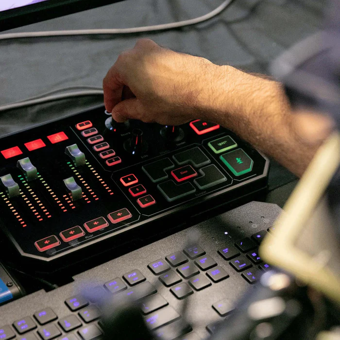 Streamer adjusting GoXLR knobs while gaming on keyboard