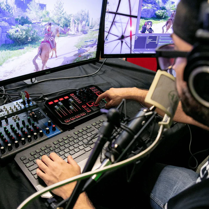 Gamer streaming with GoXLR mixer, dual monitors, and microphone